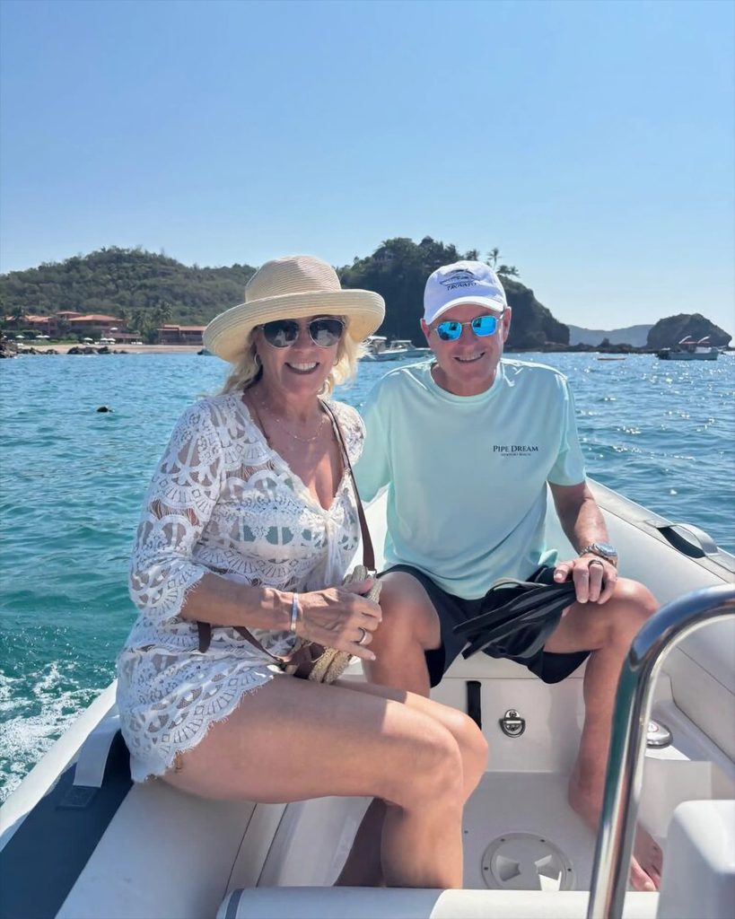 Devin Doyle and his wife enjoying a tropical boat ride on clear blue water.